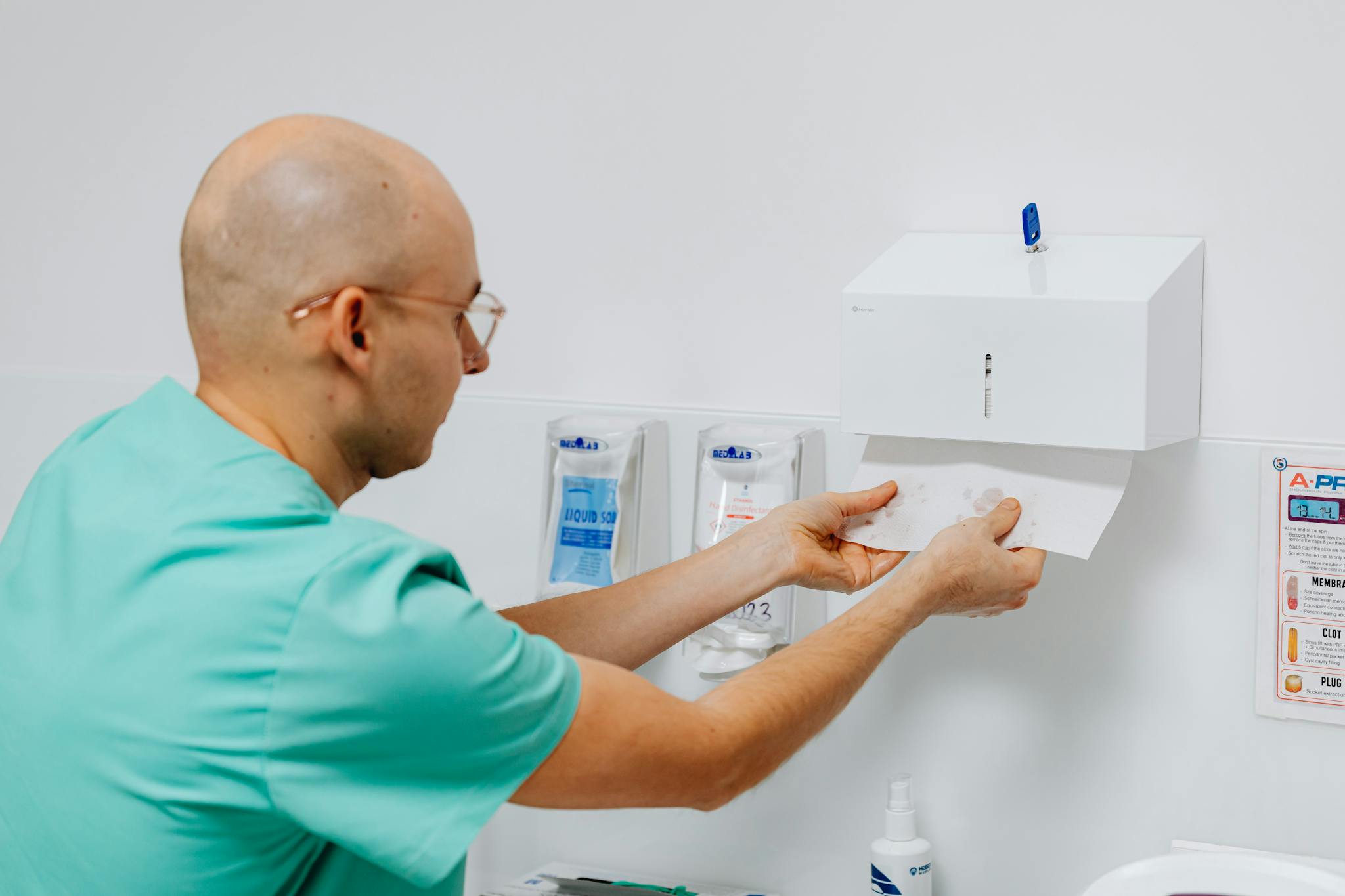 Doctor using a hand towel dispenser in a clinical setting, emphasizing hygiene.